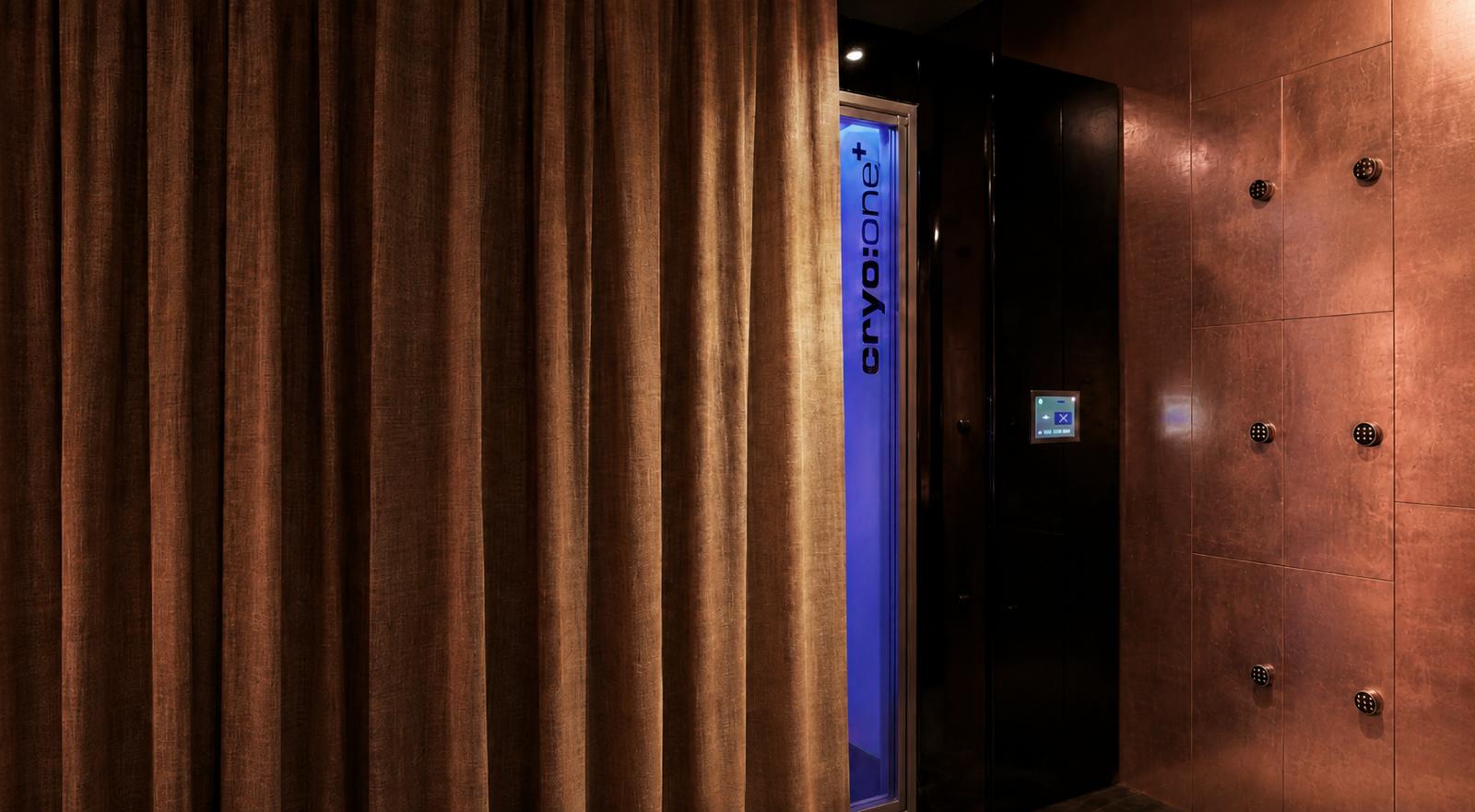 Cryotherapy chamber framed by a copper-toned curtain